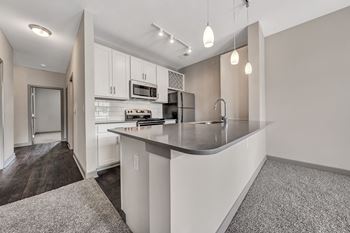 A kitchen with white cabinets and a gray counter top